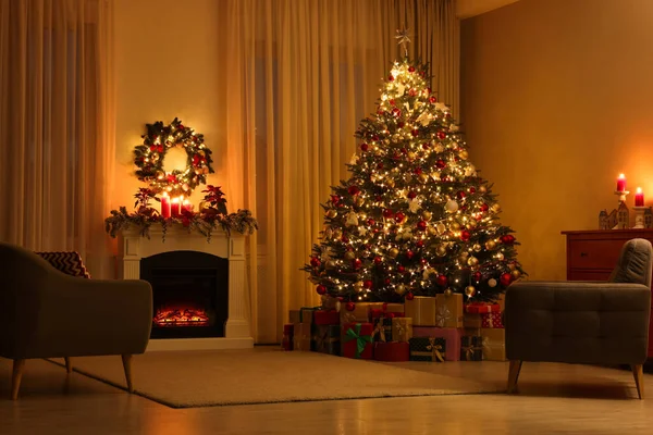 美しいクリスマスツリーとお祝いの装飾されたリビングルームの暖炉の近くの贈り物 — ストック写真
