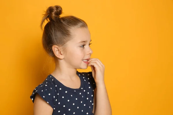Χαριτωμένο Κοριτσάκι Τρώει Νύχια Της Πορτοκαλί Φόντο Χώρος Για Κείμενο — Φωτογραφία Αρχείου