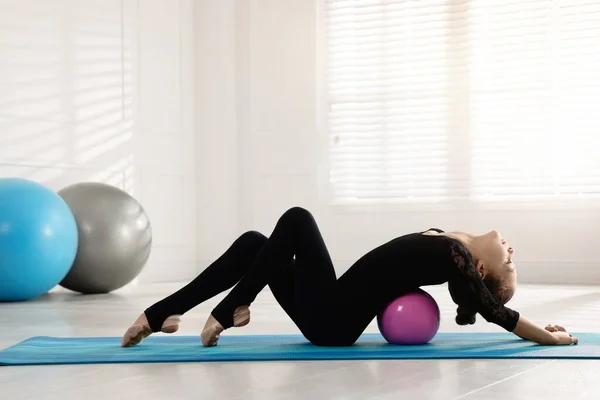 Mignon Petit Gymnaste Avec Balle Étirant Sur Tapis Intérieur — Photo