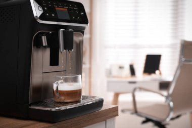 Modern espresso makinesi ofiste fincana kahve dolduruyor. Metin için boşluk