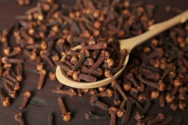 Kaşık ve aromatik kuru karanfiller ahşap masada, yakın plan.