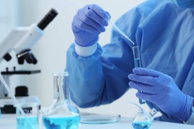 Laboratuvardaki deney tüpüne numune damlatan bilim adamı, yakın plan. Tıbbi araştırma