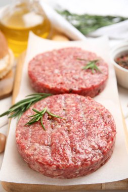 Tahtada biberiyeli çiğ hamburger köfteleri, yakın plan.