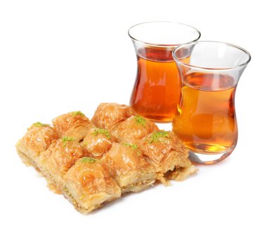 Fıstıklı enfes baklava ve beyaz arka planda sıcak çay.