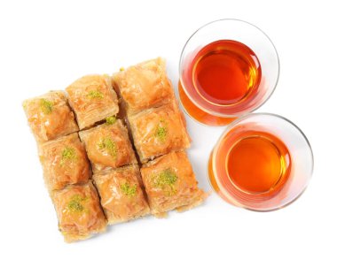 Fıstıklı enfes baklava ve beyaz arka planda sıcak çay.