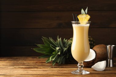 Lezzetli Pina Colada kokteyli ve ahşap masa malzemeleri, metin için yer.