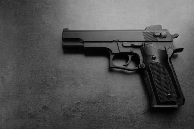 Taş masadaki siyah metal silah, üst görüş.