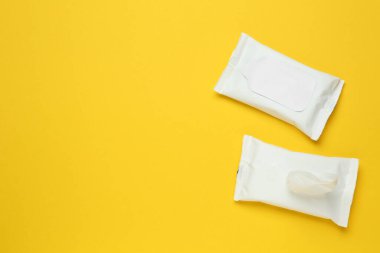 Islak mendiller sarı arka planda, düz yerde. Metin için boşluk 