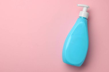 Pembe arka planda bir şişe sıvı sabun, üst manzara. Metin için boşluk