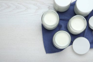 Beyaz ahşap masada cam kavanozlarda lezzetli yoğurt, düz yatak. Metin için boşluk