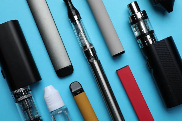 Verschiedene Elektronische Zigaretten Und Flüssige Lösung Auf Hellblauem Hintergrund Flach — Stockfoto