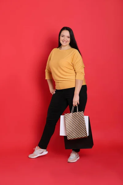 Hermosa Mujer Con Sobrepeso Con Bolsas Compras Sobre Fondo Rojo — Foto de Stock