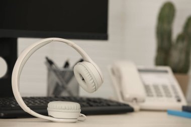 Modern kulaklıklar, masaüstü telefon ve bilgisayar kapalı masa, metin için boşluk