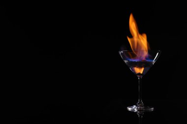 Siyah arka planda yanan votkalı kokteyl bardağı, metin için yer