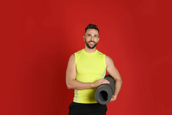 Hombre Guapo Con Esterilla Yoga Sobre Fondo Rojo — Foto de Stock