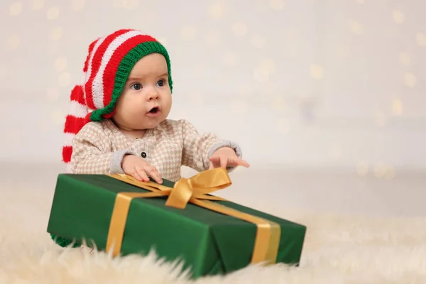 Cute Baby Kapeluszu Elfa Prezentem Świątecznym Puszystym Dywanie Przed Rozmytymi — Zdjęcie stockowe