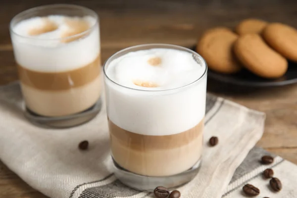 Leckere Latte Macchiato Und Kaffeebohnen Auf Holztisch — Stockfoto