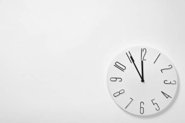 Beyaz duvarda asılı analog saat, yazı için boşluk. Yeni yıl geri sayımı
