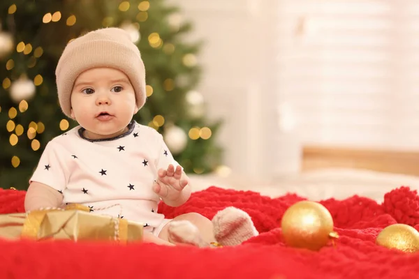 Cute Little Baby Prezentem Czerwony Koc Przed Rozmazane Świąteczne Światła — Zdjęcie stockowe