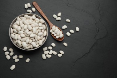 Siyah masada çiğ beyaz fasulye, düz uzanmış. Metin için boşluk