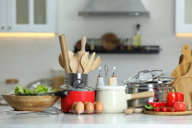 Mutfaktaki beyaz masadaki mutfak gereçleri ve ürünler.
