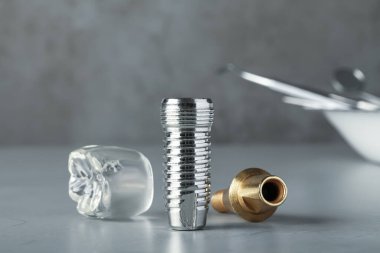 Gri masaya diş implantı parçaları, yakın plan.