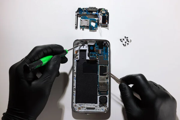 Technicus Repareert Kapotte Smartphone Aan Witte Tafel Bovenaanzicht — Stockfoto