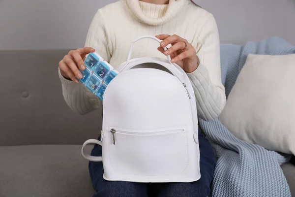 Woman Putting Plastic Box Pills White Backpack Sofa Home Closeup — Stock Photo, Image