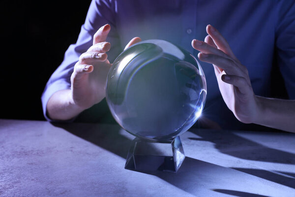 Businesswoman using ball to predict future at table, closeup