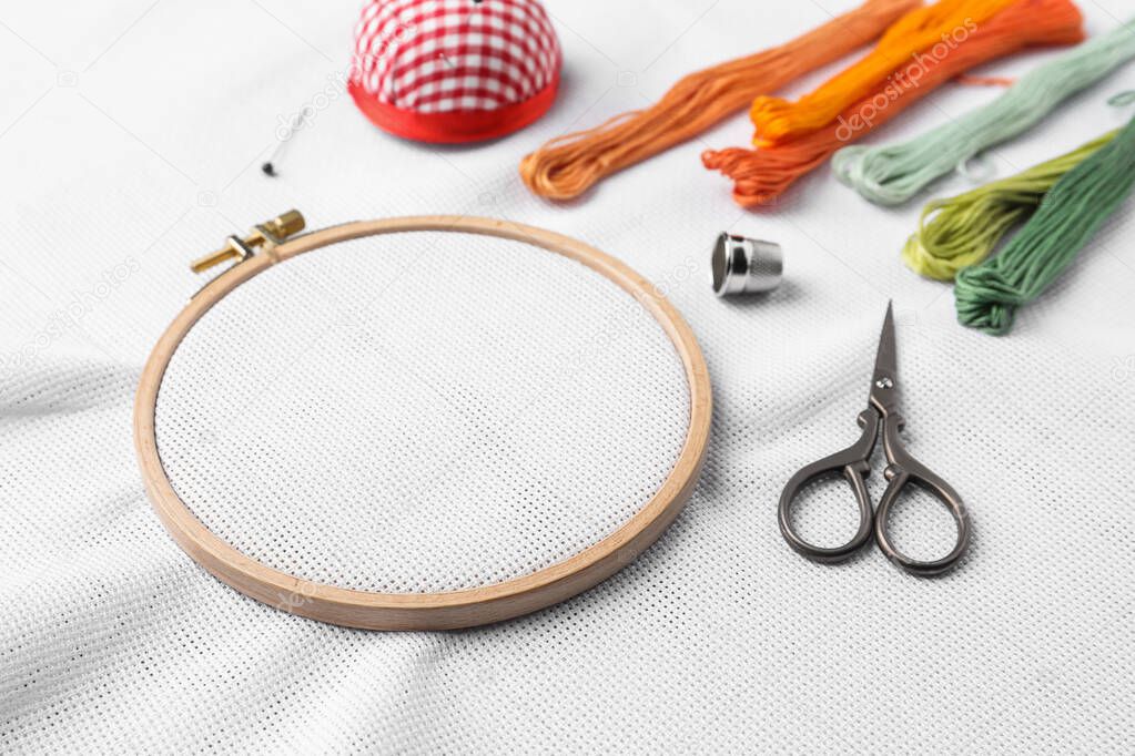 Embroidery hoop with white fabric and other accessories
