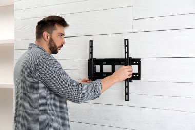 İçerideki duvara televizyon desteği kuran adam