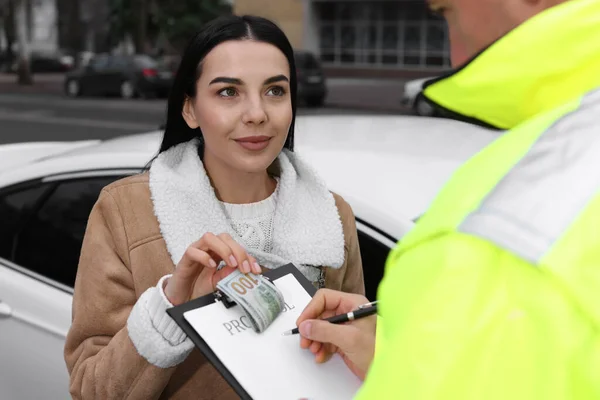 Женщина Дает Взятку Офицеру Полиции Возле Машины Улице — стоковое фото