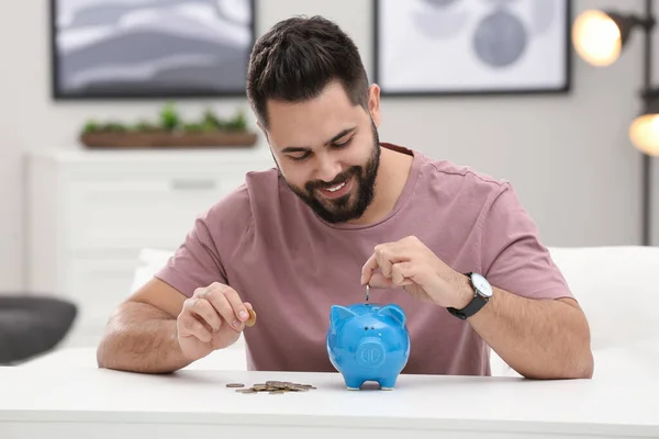 Joven Feliz Poniendo Dinero Alcancía Mesa Blanca Interior — Foto de Stock