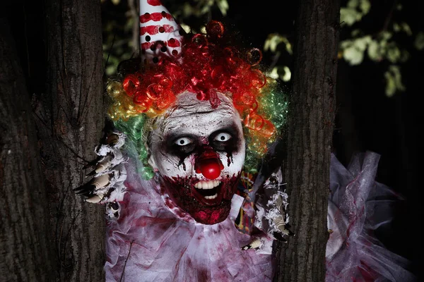 Schrecklicher Clown Der Sich Nachts Freien Hinter Bäumen Versteckt Halloween — Stockfoto