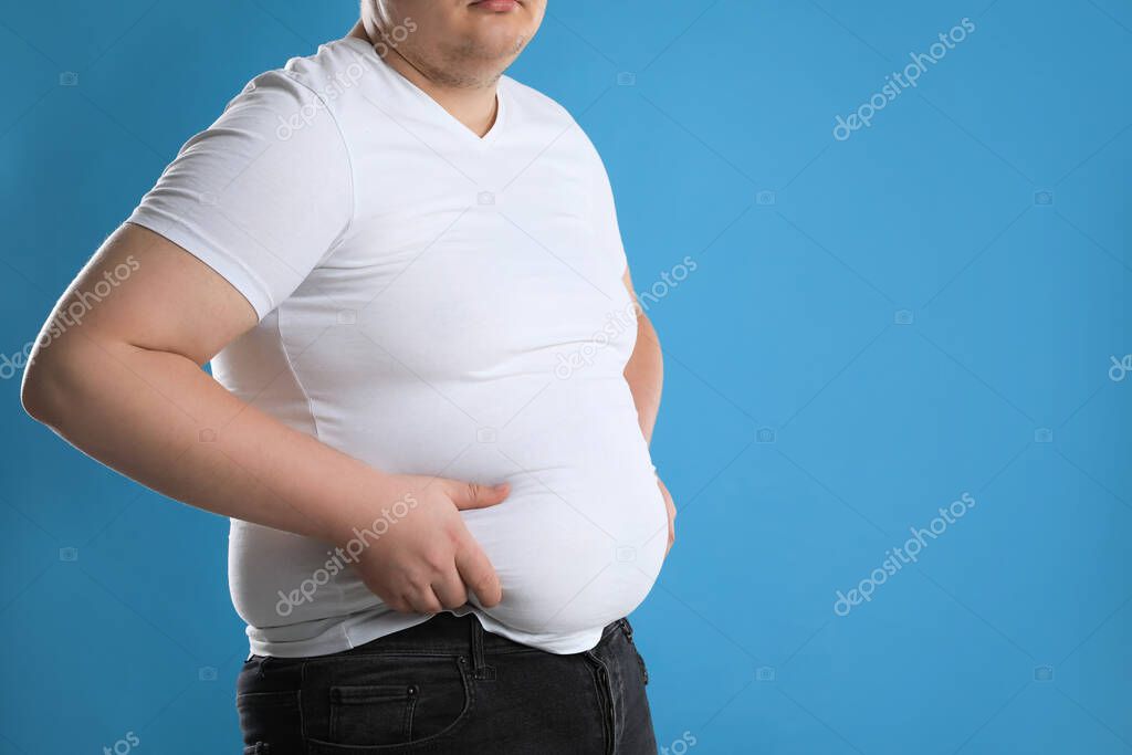 Fotos de Hombre Con Sobrepeso Camiseta Ajustada Sobre Fondo Azul Claro  Primer - Imagen de © NewAfrica #543133288