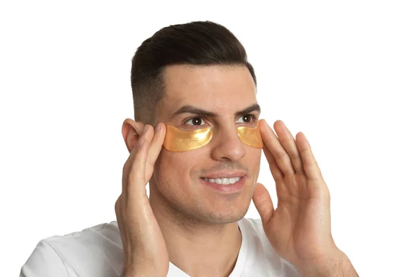 Άνδρας Που Εφαρμόζει Χρυσά Κάτω Από Μάτια Μπαλώματα Λευκό Φόντο — Φωτογραφία Αρχείου