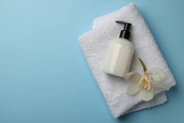 Bir Şişe Sıvı Sabun Havlu Çiçek Açık Mavi Arka Planda — Stok fotoğraf