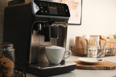 Modern kahve makinesi ofis mutfağında cappuccino yapıyor, metin için yer var.