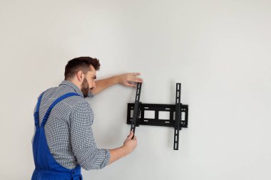 Profesyonel teknisyen içeride duvara televizyon parantezi yerleştiriyor