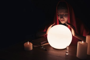 Kahin, karanlıkta geleceği tahmin etmek için parlak kristal küre kullanıyor. Yazı için yer var. Falcı.