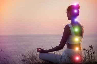 Denize yakın meditasyon yapan bir kadın. Yedi çakranın şeması, illüstrasyon
