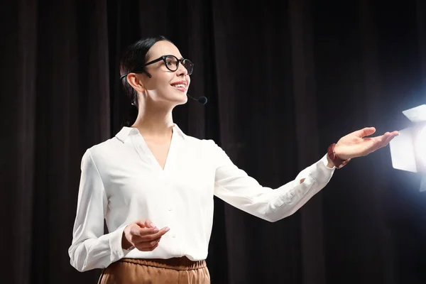 Motivational speaker with headset performing on stage