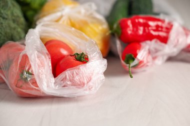 Beyaz masada yeni ürünlerin olduğu plastik torbalar, yakın plan.