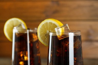 Buzlu ferahlatıcı soda bardakları ve bulanık arka planda limon dilimleri. Yakın plan.