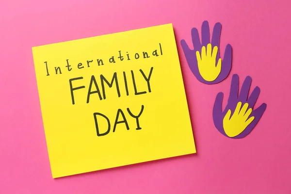 Papierhandflächen Und Karton Mit Text Internationaler Familientag Auf Rosa Hintergrund — Stockfoto