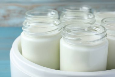 Dolu kavanozları olan modern yoğurt üreticisi, yakın plan.