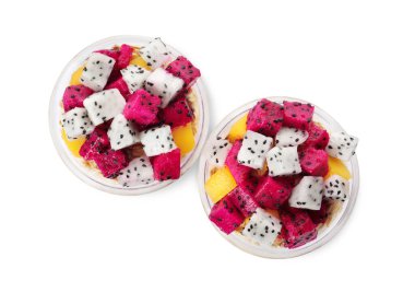 Beyaz arka planda pitahaya ve mangolu granola bardakları.