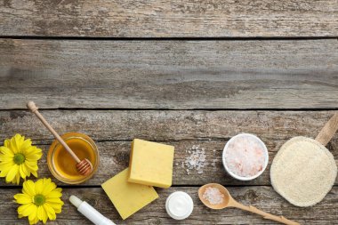 Balmumu ve kozmetik ürünlerle ahşap masanın üzerinde düz bir kompozisyon vardı. Metin için boşluk