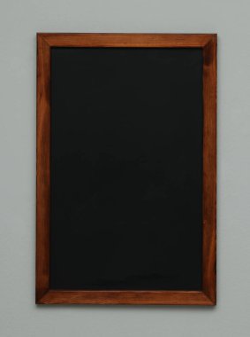 Gri duvarda asılı temiz siyah karatahta