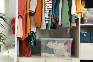 Kıyafet dolabında farklı kıyafetler ve ev eşyaları var. Hızlı moda.